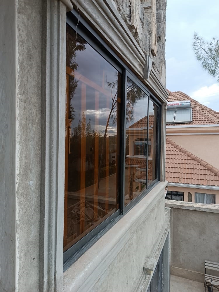 Sample brown aluminium sliding window with three sliding panels and no aluminium fixed partitons