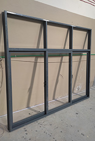 Sample colour grey aluminium sliding window with three sliding panels and a top fixed glass partition